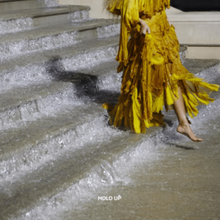 Cover art for "Hold Up": Beyoncé in a yellow dress, walking down a flooded staircase