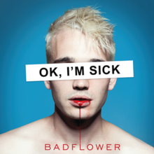 The cover has a blue background that's occupied by a blonde-haired man with blood dripping from his mouth into the band's name. A white rectangle with the album title is covering the man's eyes.