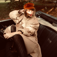 Cover of "All Too Well (10 Minute Version)", showing Swift wearing a red beret and beige trench coat, sitting in a convertible