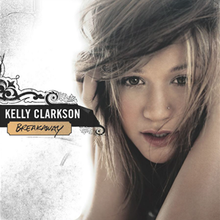 A brunette haired woman with her hands covering her ears in a grunge white background; to her right, the words "Kelly Clarkson" and "Breakaway" are printed in front of a vector scroll art.