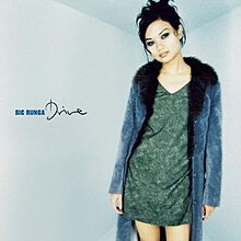 An image of Runga wearing a blue coat and green dress standing center-right in front of a blue backdrop. Her name and the album title are located to her left.