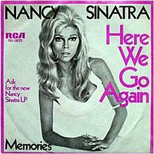 Black and white cover art photo of Nancy Sinatra on one elbow in a white dress. The border is purple as is some of the captioning. Caption says Nancy Sinatra in black. Side captions detail the record label and the song name in purple. The bottom caption has the B-side song name, "Memories".