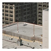 A picture of a single car on a rooftop, surrounded by a white border.