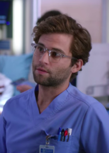 A photo of Levi Schmitt in blue surgical scrubs.