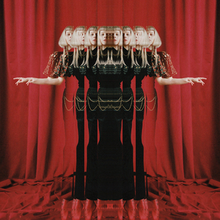 An edited photograph of Aurora that shows several reflections of her with a dark green dress, while standing on tiptoes. Behind her is a backdrop of red curtains that also cover the lower corner of the image.
