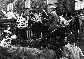 The Quarrymen performing in Rosebery Street, Liverpool, on 22 June 1957[1] (Left to right: Hanton, Griffiths, Lennon, Garry, Shotton and Davis)