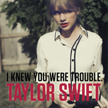A portrait of Swift in a white collar shirt holding her sunglasses while staring upwards. The title "I Knew You Were Trouble" is printed in black, and her name Taylor Swift is printed in red, both are printed in uppercase letters, at the bottom of the photo.