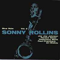 A blue-tinted photograph of Rollins playing the saxophone against a black background. The album title and artist's name are displayed in bold blue text on the right side, with the names of contributing musicians—Jay Jay Johnson, Horace Silver, Thelonious Monk, Paul Chambers, and Art Blakey—listed below. The Blue Note logo and catalog number (1558) are positioned on the left.