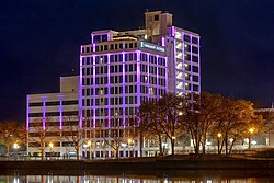 A photo of a brightly and colorfully lit renovated hotel near the Rock River in Rockford, Illinois that used to be the Ziock building