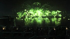 Screenshot from the episode, featuring the green "wildfire" explosion at night over a body of water