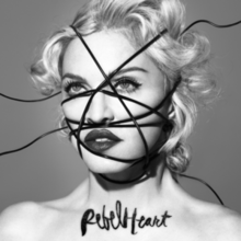 Black-and-white image of Madonna, with black strings going criss-cross over her face, with "Rebel Heart" written on her chest