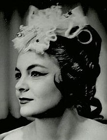 Publicity profile shot of a young woman in heavy operatic makeup and headgear.