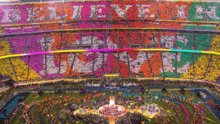 A set of rainbow-coloured placards read as "Believe in Love" in a stadium