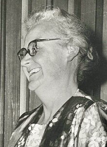 Monochrome portrait of Hardwich. She is shown in profile and looking to the left. She is wearing glasses and a blouse decorated with flowers.