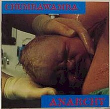 a photo of a baby’s head emerging from a vagina. “Chumbawamba” is written in red all-caps on a blue background in the upper left corner; “Anarchy” is written in the same style in the lower right corner.