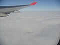 After takeoff - on the cruise climb phase; note the plane's shadow on the clouds