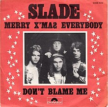 A monochrome photograph of Slade, with a white border, set almost centrally in a red square. The words "SLADE" dominate the cover, underneath which is written "MERRY X'MAS EVERYBODY". Underneath the photograph are the words "DONT BLAME ME". White stars border the left and right sides of the photograph.