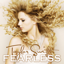 The cover artwork of Taylor Swift's 2008 album Fearless, showing Swift's side profile with blonde curly hair. An action shot, her hair appears to burst outwards.