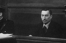A middle-aged man sitting in the dock of a courtroom