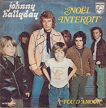 Johnny Hallyday with a group of children, tweens, and teens, below him is his son David, aged 7 at the time. Photography by Tony Frank.