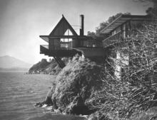 Screenshot of a digitized ROMA brochure. Image shows the Matzinger House perched on the edge of a lake. The house features large windows, an extended balcony, and Japanese-style woodwork.