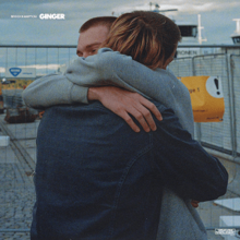 Two members of Brockhampton (JOBA and Weston Freas) hugging each other on the street.