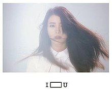 In the centre of a white page is a blue-lit rectangle with a mid-shot of a woman with long dark hair partially covering her face. Underneath the picture in the middle is the title I U, with an elongated box in the middle.
