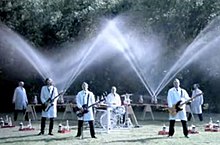 Weezer plays in the foreground while Fritz Grobe and Stephan Voltz set off Diet Coke and Mentos eruptions behind them in the "Pork and Beans" music video. Three members of the band are playing guitar while the other (Pat Wilson) is playing the drums. They are all wearing white tops and black pants.