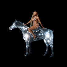 Beyoncé in a spiky silver metal body suit sits on top of a silver disco ball horse