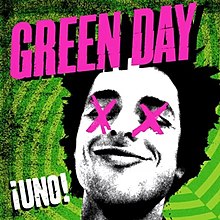 A black-and-white cutout of Billie Joe Armstrong's head, with his eyes crossed-out with pink X's, on a geometric, neon electric green background. The word "Green Day" is loudly splashed in pink across the top of the cover, while the Spanish word "¡Uno!" is sprawled graffiti-style in white in the lower left-hand corner.
