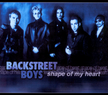 The band is standing against a wall facing the camera, with a blue filter. The band name and song title are positioned underneath them.