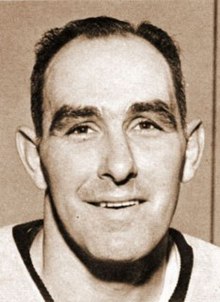 Black and white facial photo of a man wearing a hockey jersey
