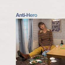 Cover art of Anti Hero, shows Swift sitting in a corner of a tiny house.