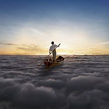 A man in a white shirt and tan pants stands in a Thames skiff at the center of the image. He stand-up paddles the Thames skiff across a sea of clouds, heading towards the sun.