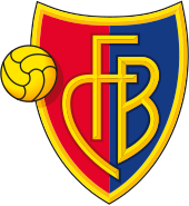 FC Basel crest of a shield, the left half red and the right half blue. The shield is outlined with gold and in the centre in gold letters it reads "FCB". On the left side of the logo is a gold football.