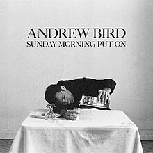 A black-and-white photo of Bird slumping on a table, pouring 2% milk into glass