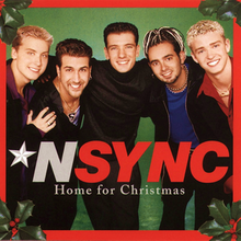 NSYNC members huddled together in front of a green background and red border with Christmas leaves on the corner. Underneath are the words: NSYNC Home For Christmas.