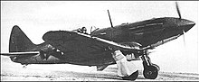 A dark-camouflaged single-engined fighter with an inline piston engine