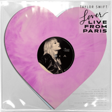 A pink heart-shaped vinyl inside of a clear slip, with the vinyl label showing a picture of Swift, and a sticker affixed to the slip displaying the title
