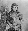 Peaches (Tsoe), a White Mountain Apache scout, full-length, holding rifle, 1885