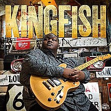 Christone "Kingfish" Ingram, holding a gold electric guitar