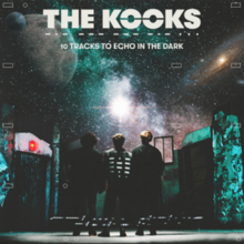 The Kooks standing on a stage with their backs to the viewer looking at a projection of outer space