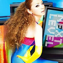 A picture of a woman wearing a latex costume surrounded by television screens.