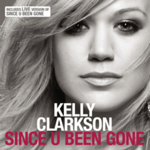 A front face image of Kelly Clarkson. She is wearing a black tank top against a grey background and her hair is swept to the right. Below her chin, the word "Kelly Clarkson" is written in white capital letters. Below the word, "Since U Been Gone" is written in pink capital letters.