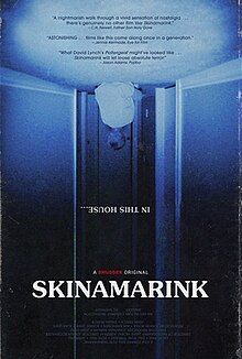 A blue, upside-down image of a young boy sitting in a hallway, advertising a film titled "Skinamarink", in all capital letters. Also upside down, the film tagline reads "In this house..." also in capital letters.