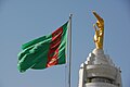 Summit of the Neutrality monument, featuring a golden statue of Saparmyrat Nyýazow with the flag of Turkmenistan in the foreground