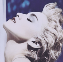 Madonna in short platinum blond hair tilting her head back.