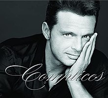 Black-and-white image of Luis Miguel resting on his left hand and facing the camera