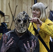 A behind the scenes picture of the fan film Jason Rising (2021) with an actor in costume as Jason, on the left, and actress Adrienne King, right, in costume as Alice