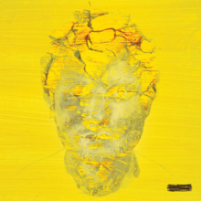A digitally manipulated photograph of Ed Sheeran's face on a yellow field and covered with yellow dirt.